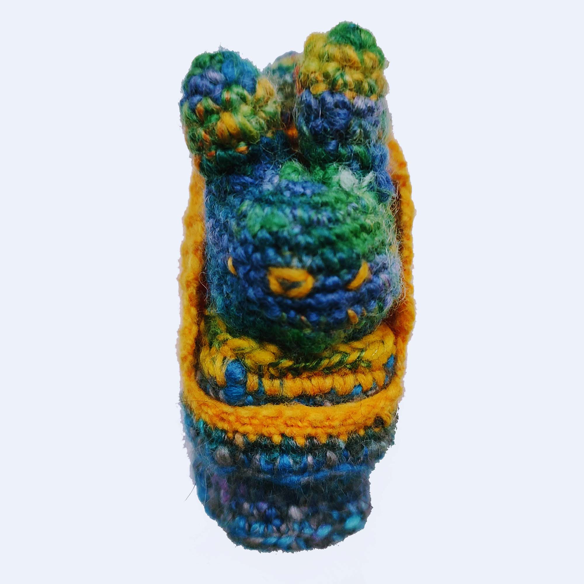 blue and yellow crocheted toy bun alien in a rocket pod