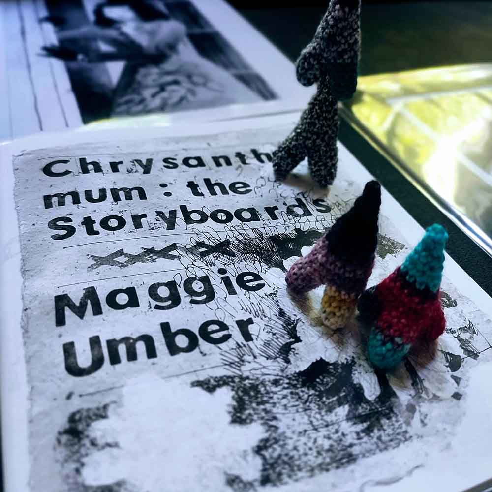 crocheted nunion toys standing on a copy of a zine, cover text reads Chrysanthemum the Storyboards, Maggie Umber